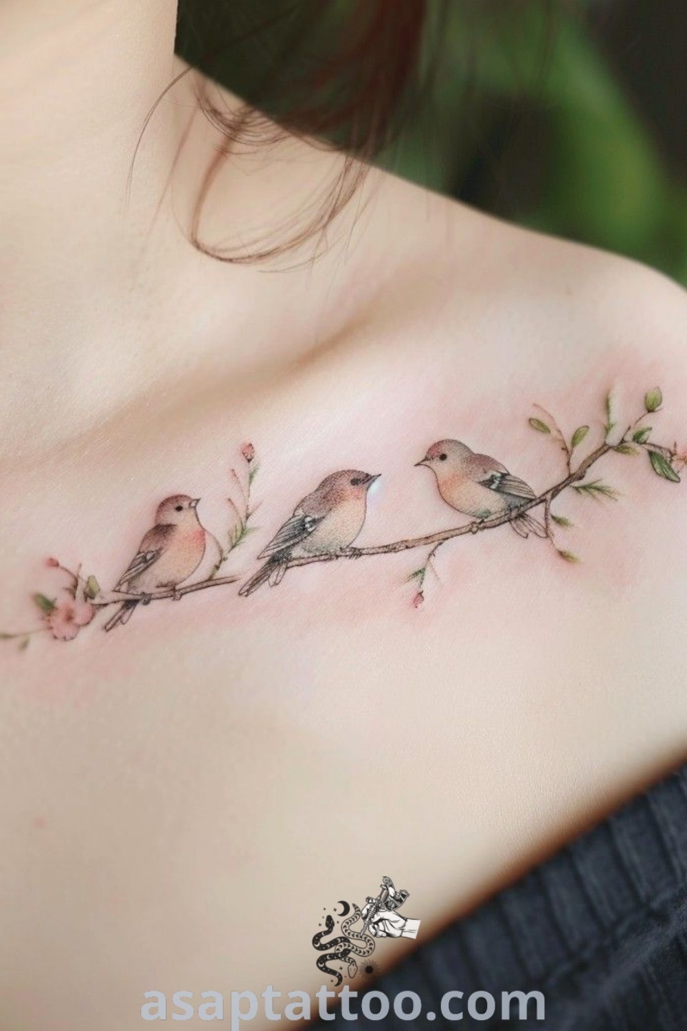 Three birds sitting on a branch tattoo surrounded by pink flowers, a beautiful choice among flower and birds tattoos, ideal for inspiring small robin tattoo ideas. Discover amazing designs at asaptattoo.com.