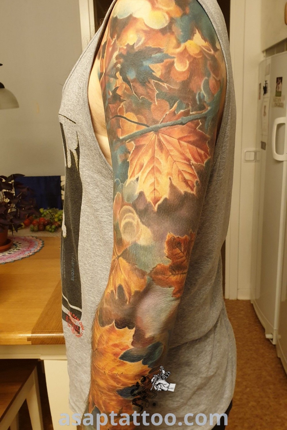 Detailed leg piece tattoo of a maple tree and leaves in the wind, symbolizing Canada and artistic expression. A stunning choice for anyone exploring tattoos with meaning. Find more at asaptattoo.com.