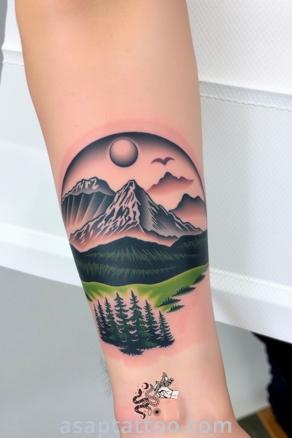 Realistic tattoo of mountains and a dense forest with intricate linework and blended green and gray shades, creating a lifelike quality. This gorgeous tattoo is an amazing idea to inspire you to get inked. asaptattoo.com