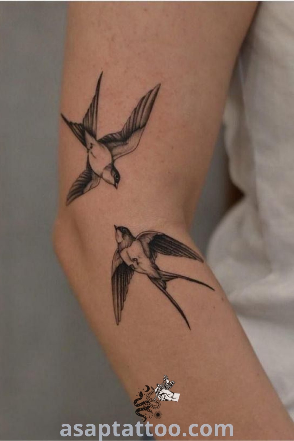 Elegant swallow tattoo depicting two small birds flying with their wings spread, an amazing design idea with meaning. Explore more tattoo inspiration at asaptattoo.com.