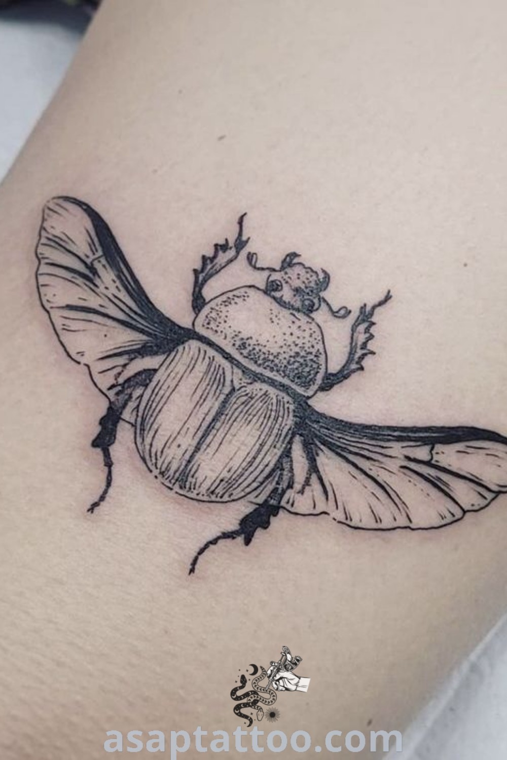 Black and white photo of a stunning beetle tattoo on the right thigh with an insect sitting on its back. This design features elements seen in American Traditional, Goliath Beetle, and Japanese Beetle tattoos. Discover more amazing tattoo ideas at asaptattoo.com.