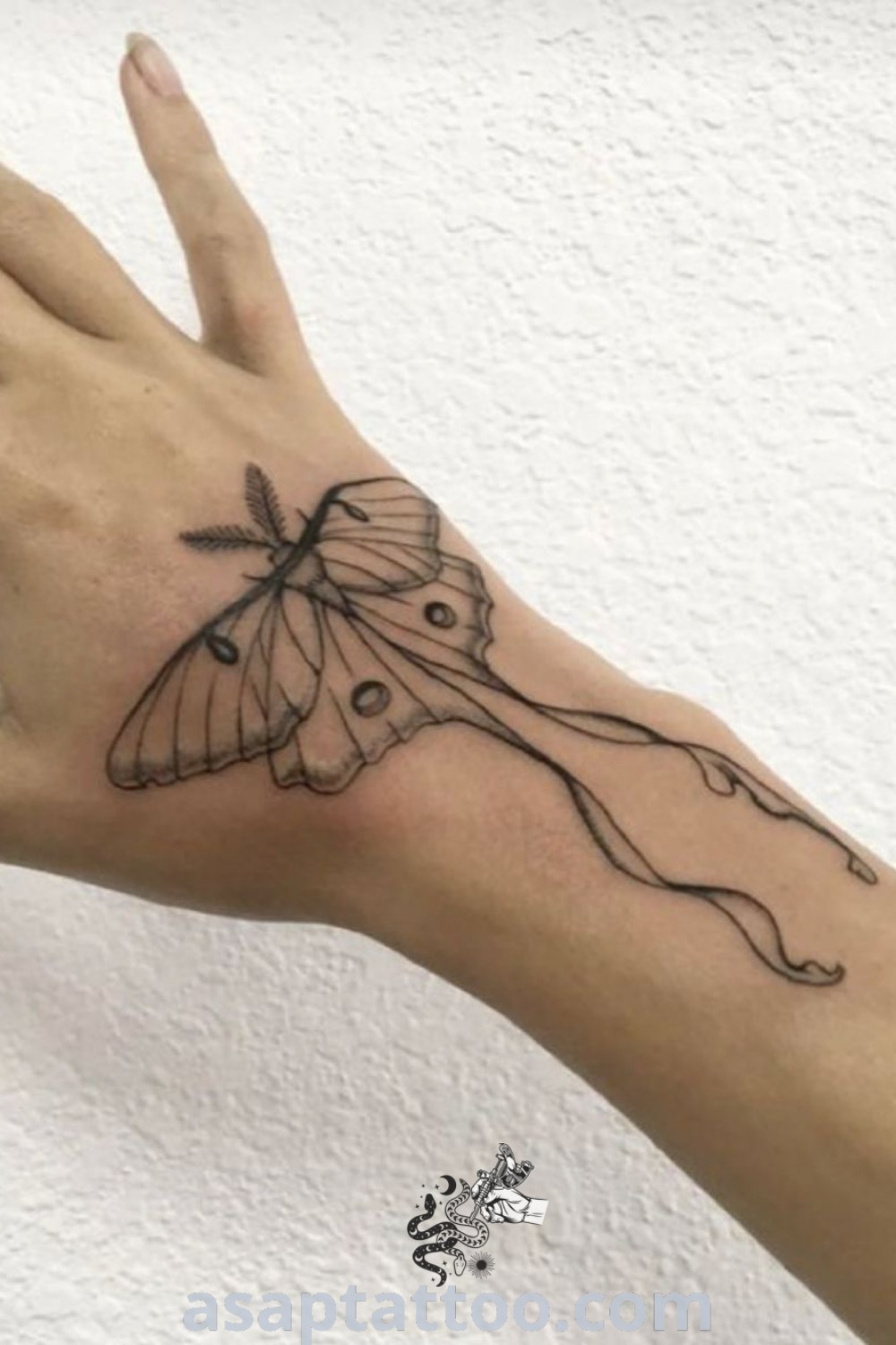 Whimsical tattoo of a hand with a butterfly on the wrist and an arrow in the middle, showcasing vintage aesthetic tattoos and moth designs. Explore more amazing ideas at asaptattoo.com.