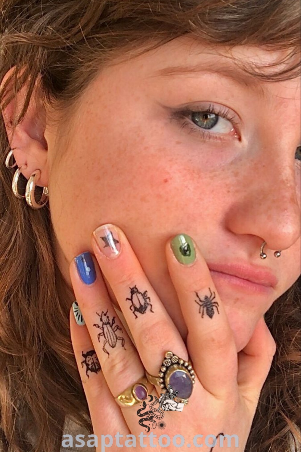 Stylish woman with finger tattoos, showcasing artistic designs like bug and insect tattoos. An inspiring image for those exploring gorgeous and meaningful tattoos. Learn more at asaptattoo.com.