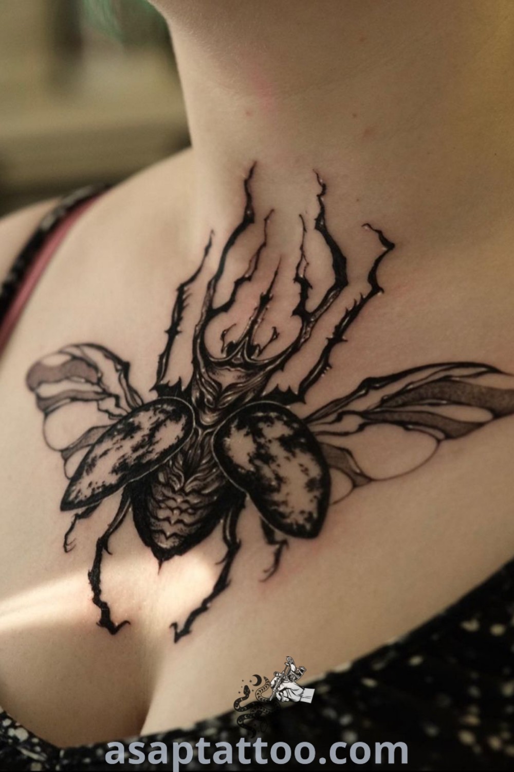 A woman with a black and white beetle tattoo on her chest, showcasing artistic and funky tattoo design. Perfect for those seeking elegant and inspiring ink ideas. Explore more at asaptattoo.com.