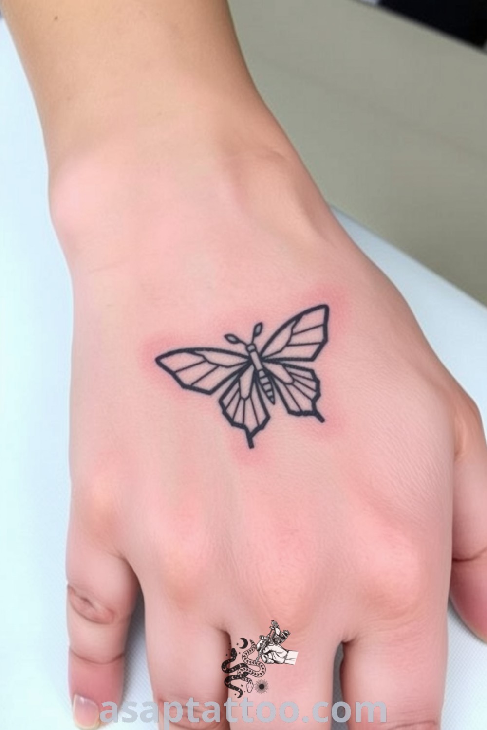 Minimalist butterfly tattoo on the back of the hand with delicate black linework and gentle shading that blends into light skin, symbolizing freedom and transformation. A gorgeous tattoo idea you must see. asaptattoo.com