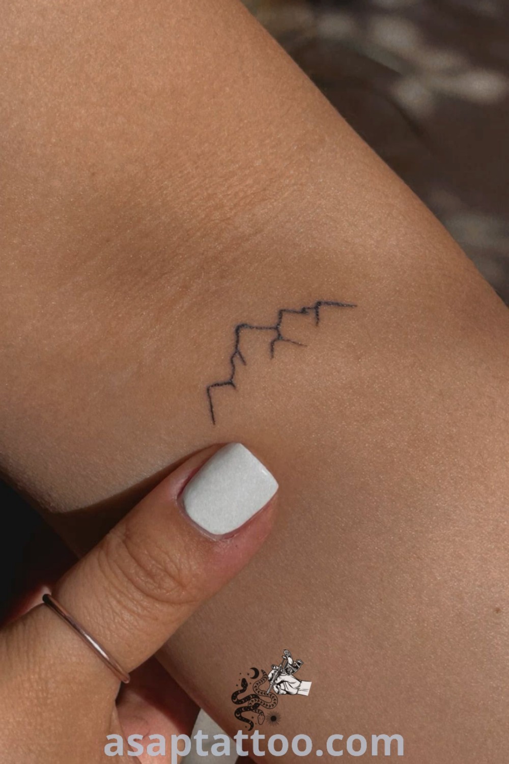 Mountain behind ear tattoo showcasing a woman