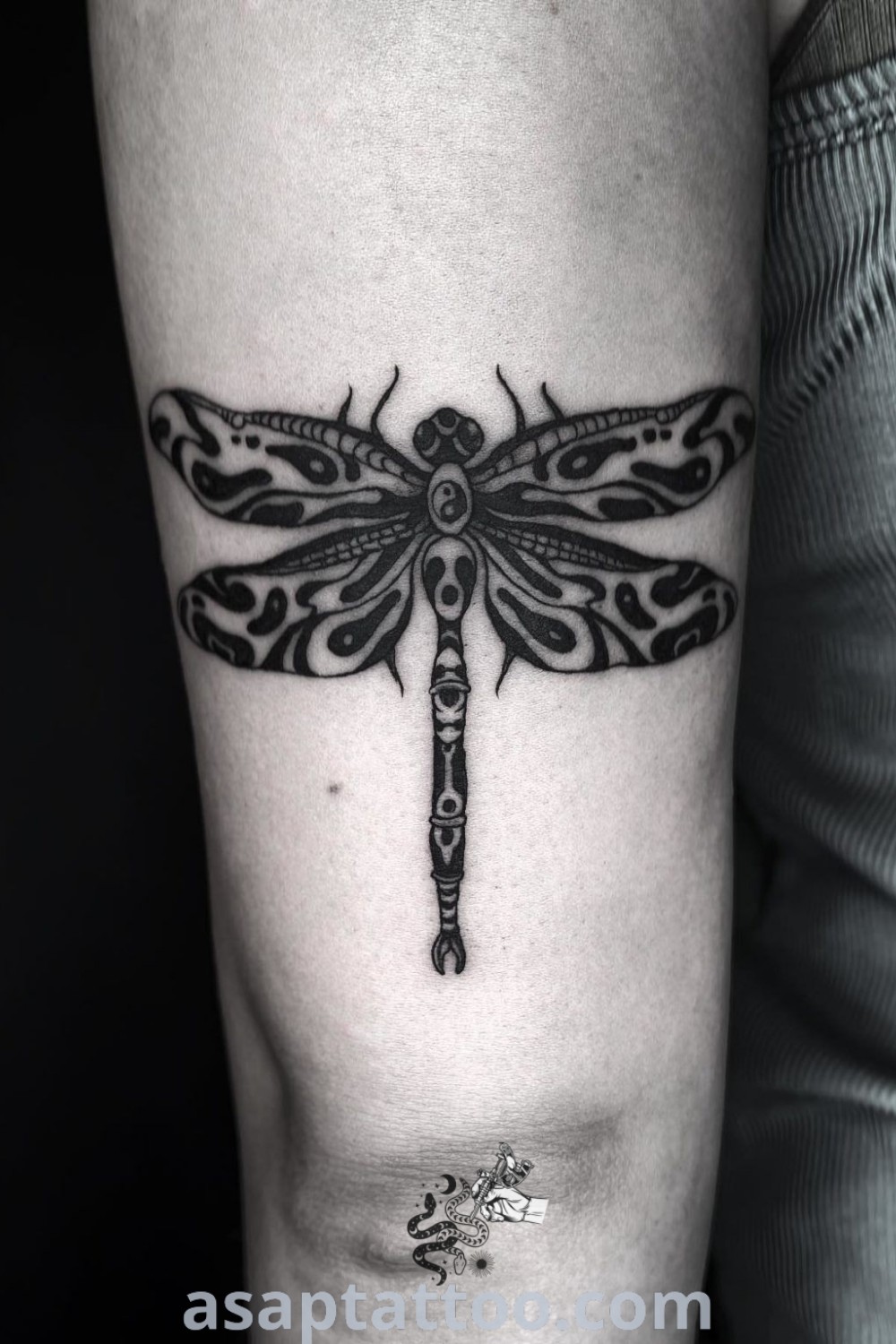 A stunning dragonfly tattoo on the arm featuring neo-traditional style with artistic elements. Perfect for those seeking elegant and meaningful tattoos. Discover more at asaptattoo.com.