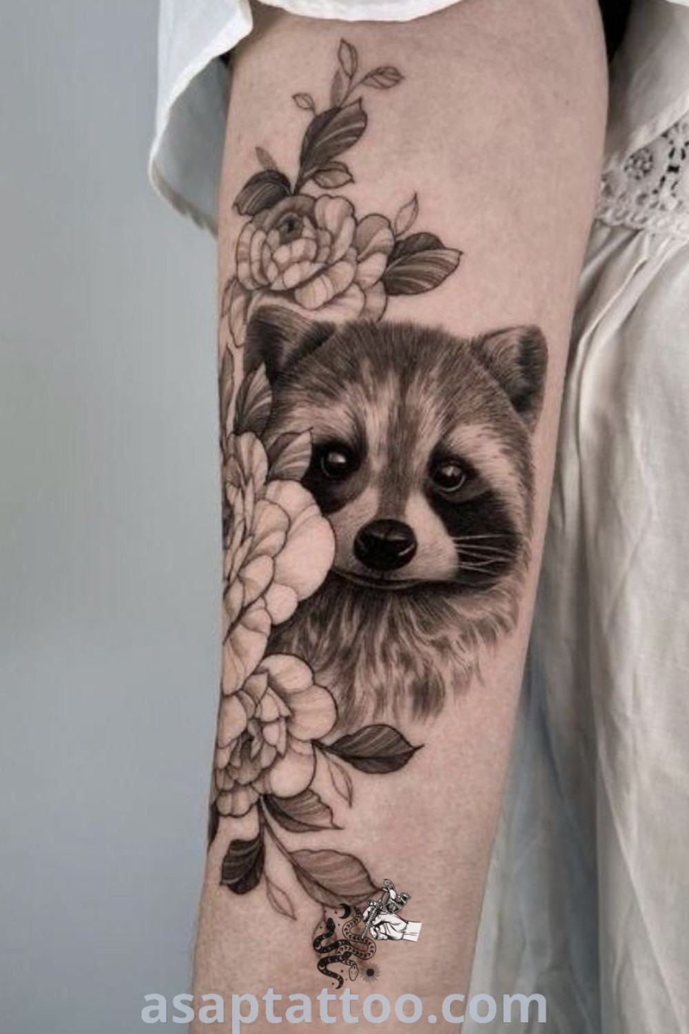 Charming raccoon tattoo with flowers on its arm, unique and cute design showcasing inspiring body art ideas. Discover more about this amazing tattoo at asaptattoo.com.