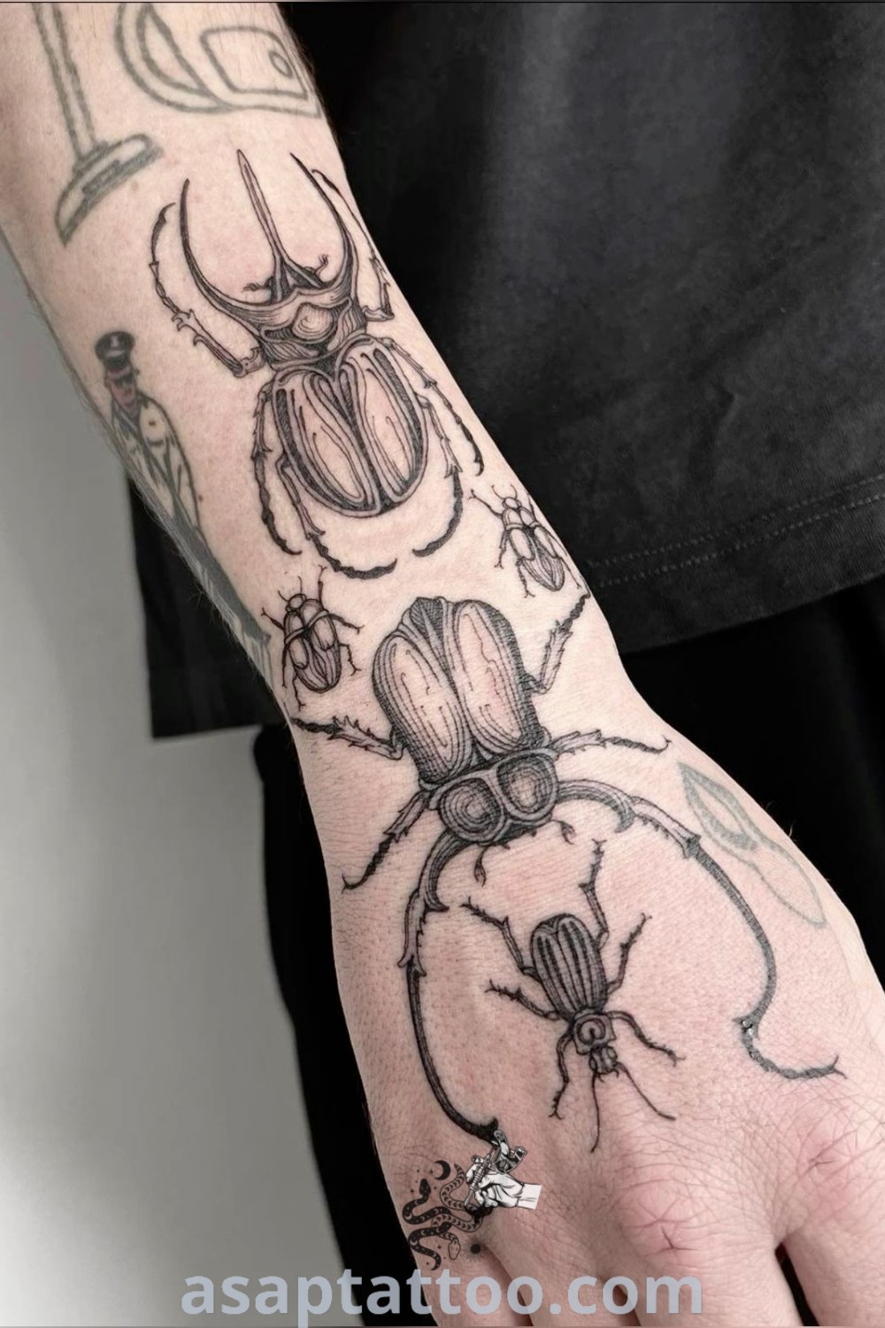Unique beetle hand tattoo showcasing a person holding a hand with two bugs, exemplifying bug sleeve tattoo artistry. A remarkable design for those seeking inspiring tattoo ideas. Discover more at asaptattoo.com.