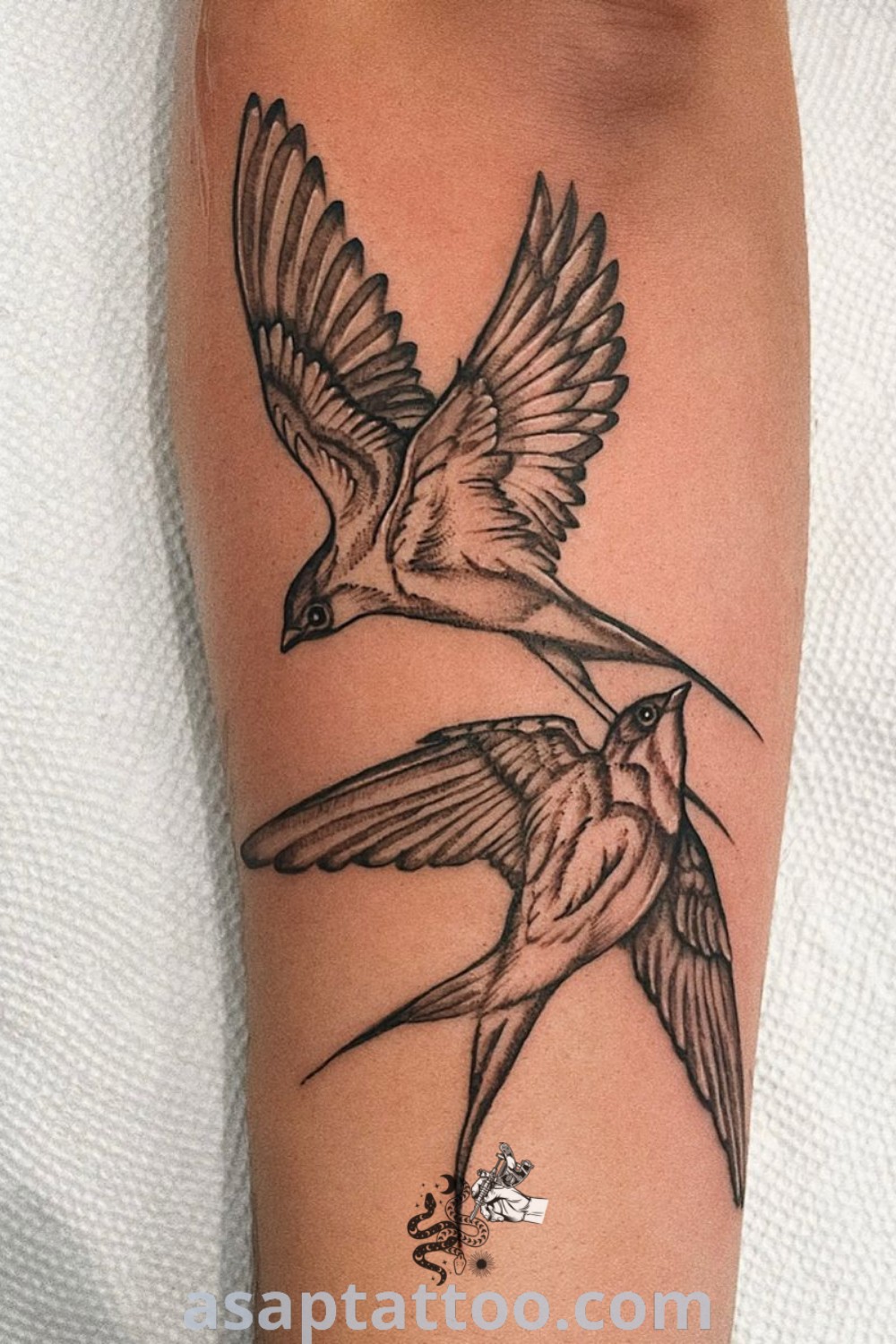 Elegant swallow tattoo with two birds, one flying away. A simplistic yet striking black ink design perfect for small tattoos for guys. Discover more inspiring tattoo ideas at asaptattoo.com.