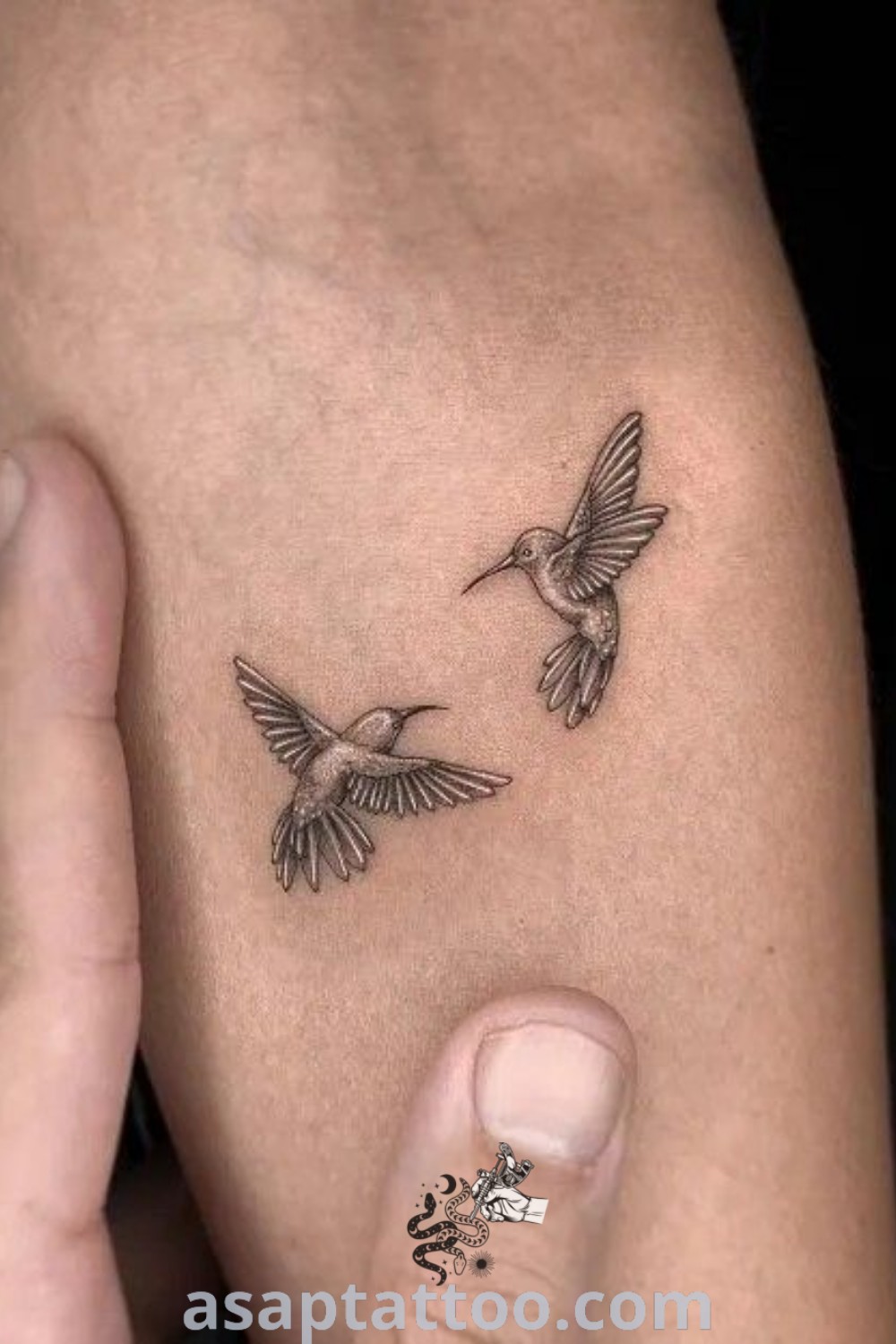A person holding their arm adorned with two small birds representing micro tattoos for women. These designs, perfect for both men and women, include artistic elements and elegant body art inspiration. Discover more amazing tattoo ideas at asaptattoo.com.
