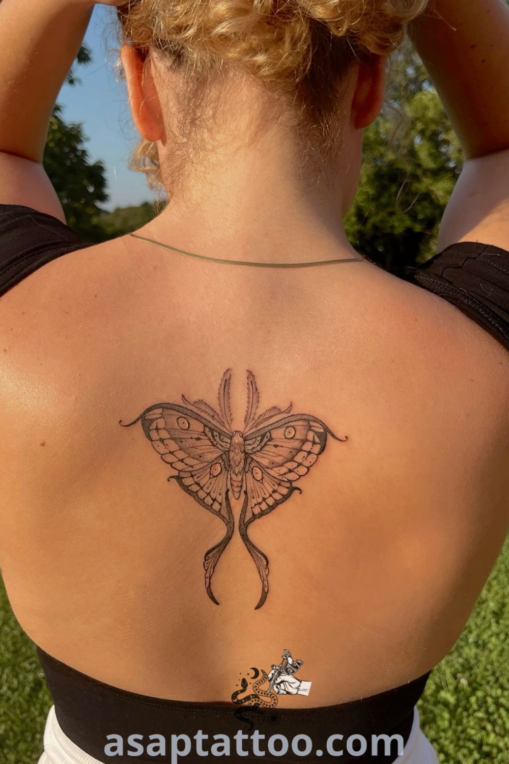 Elegant luna moth tattoo on a woman