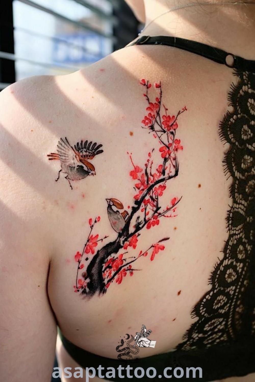 A woman with a "Tato Wolf" tattoo on her back, enhanced by beautiful flowers, showcases the best tattoo ideas. This elegant design reflects artistic flair and meaning, perfect for inspiring those seeking back tattoo inspiration. Explore more at asaptattoo.com.