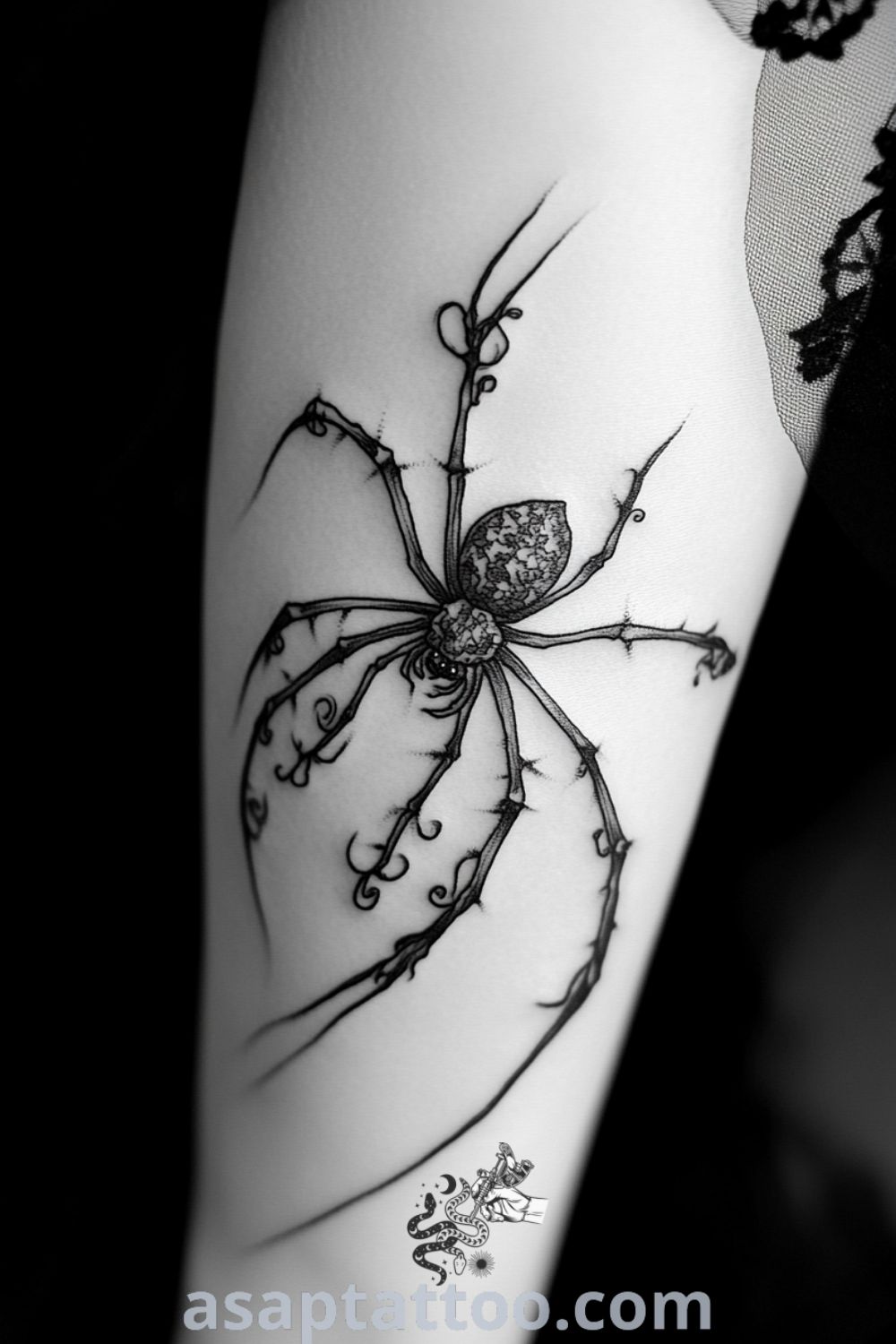 Intricate etching-style spider tattoo on elbow featuring detailed legs and body with black ink gradations. A gorgeous tattoo idea you must see to believe. asaptattoo.com