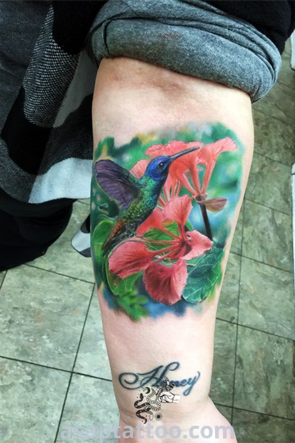 Hummingbird and flower tattoo on the right leg with the word "always" below, showcasing vibrant colors and intricate details. A perfect choice for tattoos with meaning, inspiring ideas, and elegant body art. Discover more at asaptattoo.com.