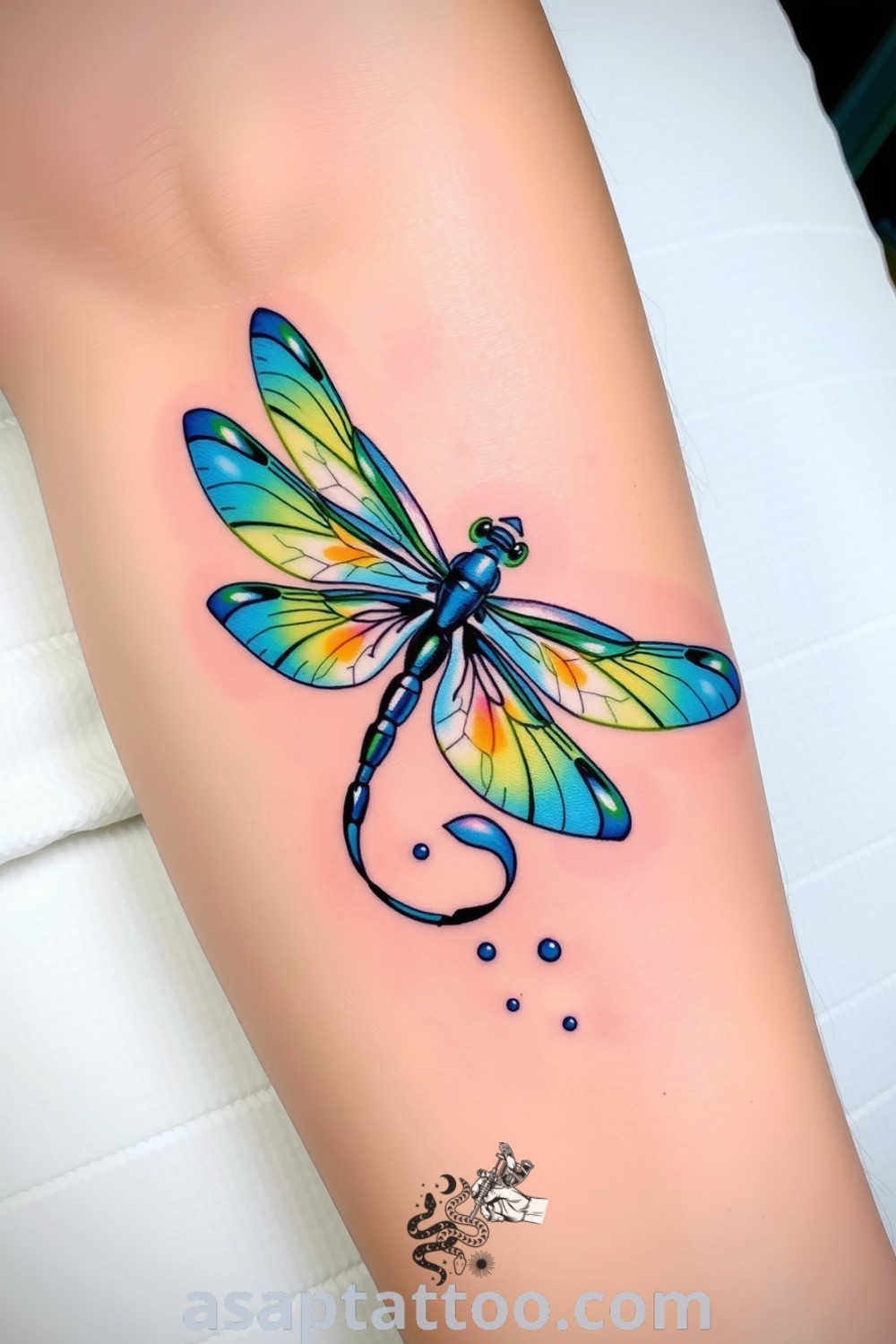 Color splash dragonfly tattoo with vibrant blue, green, and yellow hues, showcasing intricate details and a sense of movement. An amazing tattoo idea you must see that symbolizes transformation and freedom. asaptattoo.com