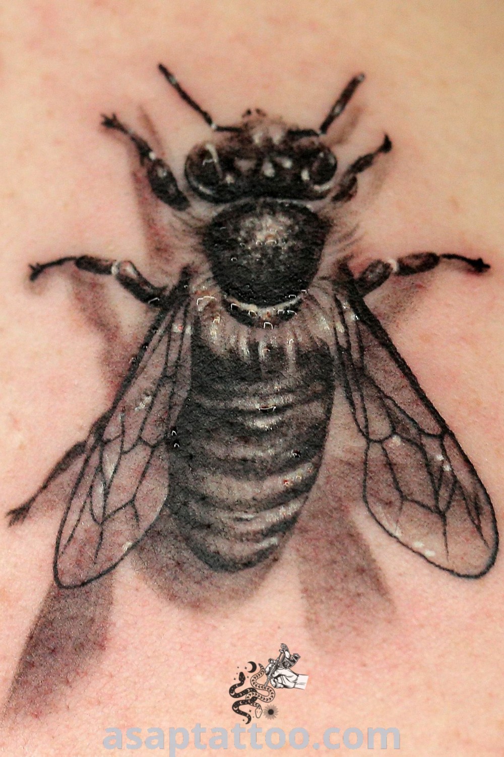 Realistic bee tattoo on the back of a woman