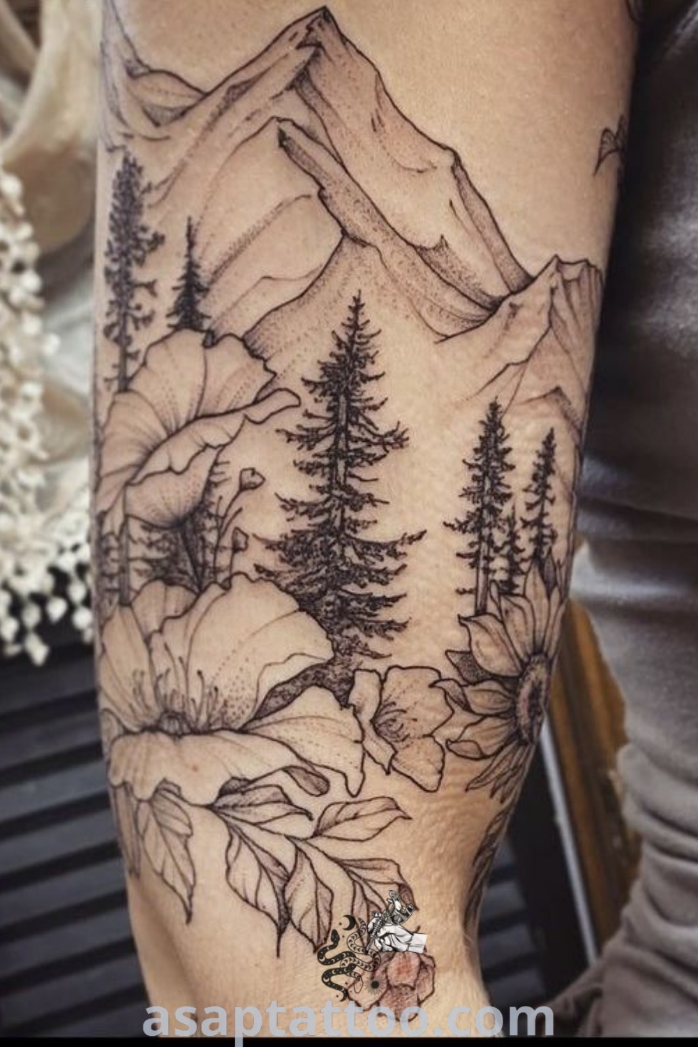 Mountain sleeve tattoo depicting mountains and trees on a woman