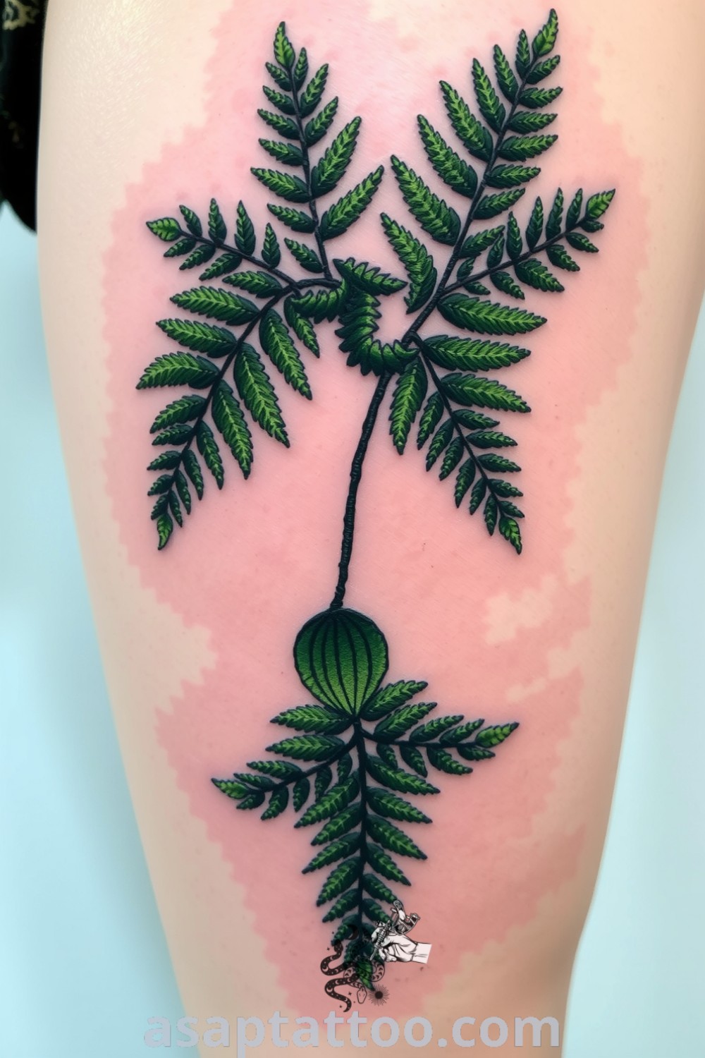 Embroidery-style tattoo of lush green ferns with intricate stitching on thigh, capturing nature