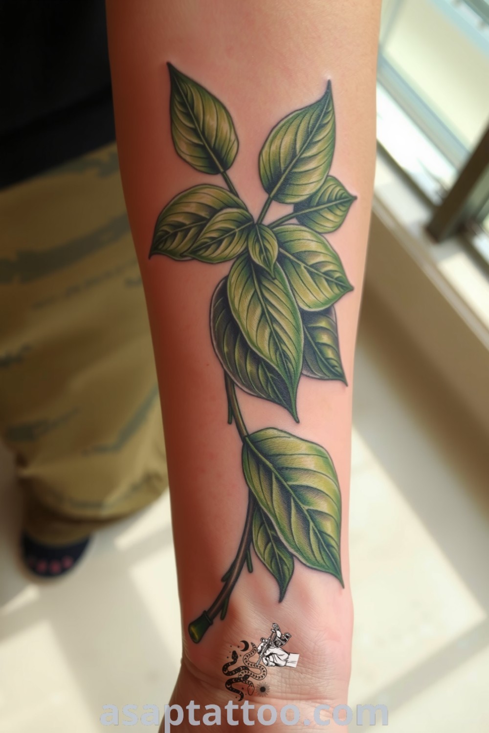 Intricate green leaf tattoo entwined on the forearm with detailed shading and gradients, creating an organic effect. An amazing tattoo idea you must see to believe. asaptattoo.com