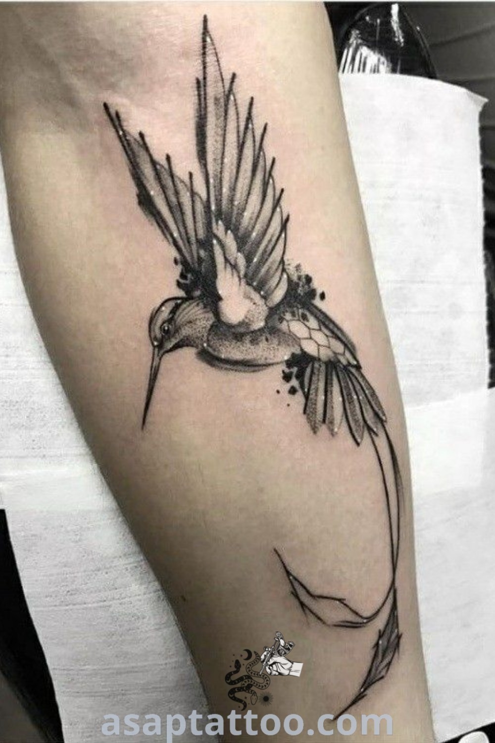 Black and white bird tattoo of a hummingbird on the arm with realistic and pointillism details. A gorgeous option for men looking for inspiring tattoo ideas at asaptattoo.com.