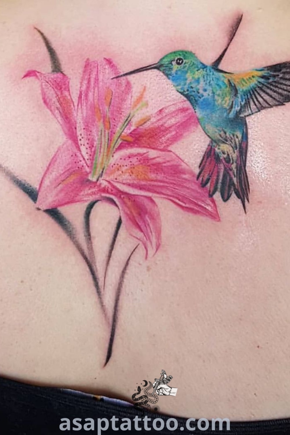 Colorful hummingbird shoulder tattoo featuring a pink flower, perfect for women seeking inspiring body art. A gorgeous tattoo idea that combines artistic elegance and vibrant colors. Find more at asaptattoo.com.