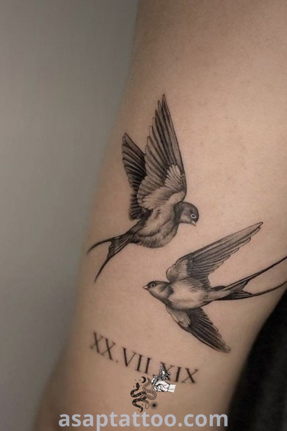 Two birds with roman numerals tattoo on the arm showcasing artistic features and negative design elements. A perfect idea to inspire men seeking inked expressions of freedom and style. More insights at asaptattoo.com.