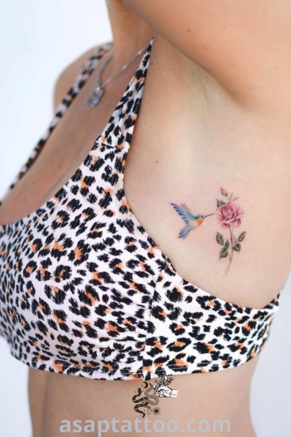 Small tattoo of a pink rose on a woman