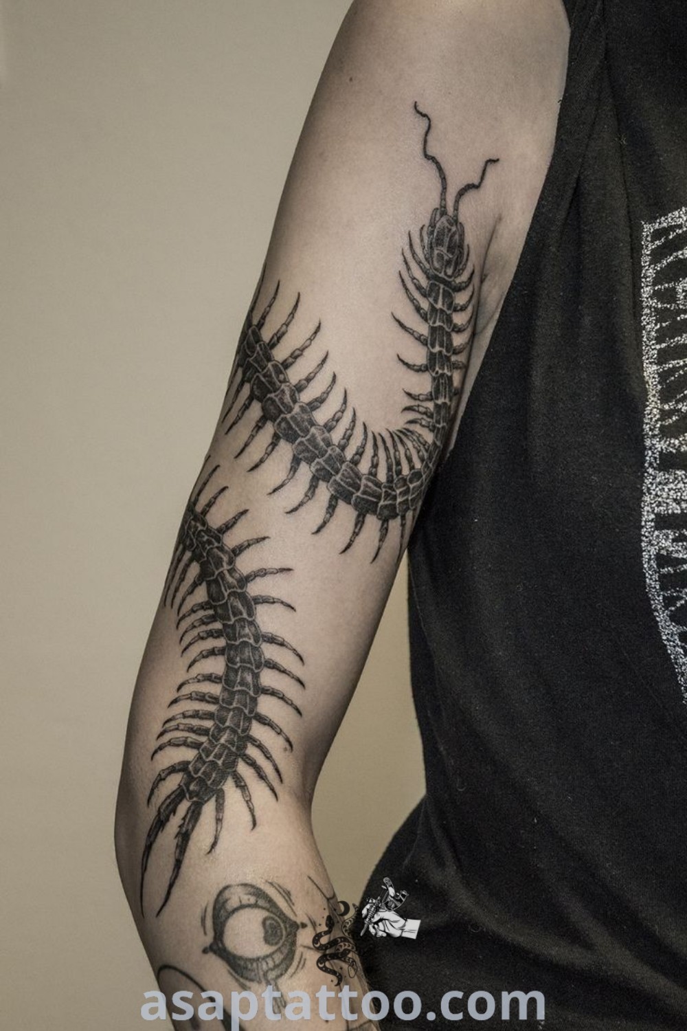 Centipede tattoo around the arm, featuring black and grey ink designs that blend artistic appeal with a creepy edge. A perfect example of creative tattoo ideas to decorate your body with, discover more at asaptattoo.com.