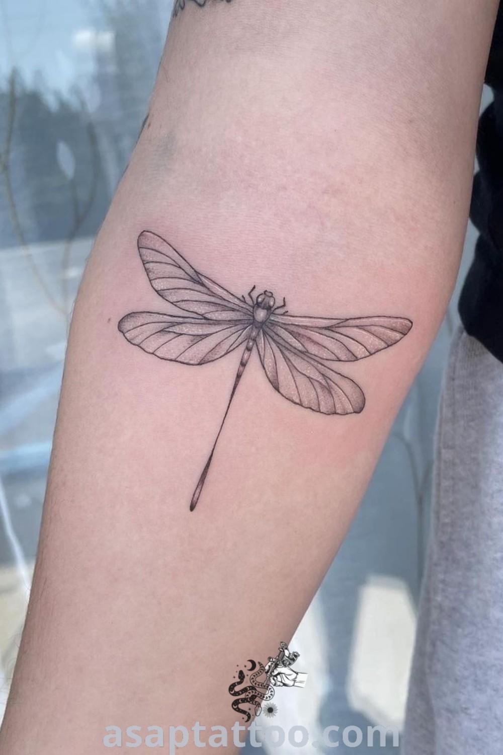 Small dragonfly tattoo on the arm representing the bond between mum and daughter. A stunning dotwork design that is both classy and meaningful. Explore more inspiring tattoo ideas at asaptattoo.com.