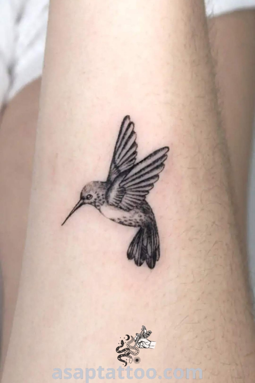 Small black and white hummingbird tattoo on the ankle, featuring delicate details that make it a cute and elegant choice. Explore more amazing tattoo ideas at asaptattoo.com.