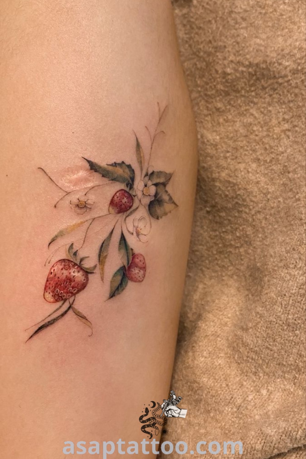 Elegant strawberry tattoo on a woman