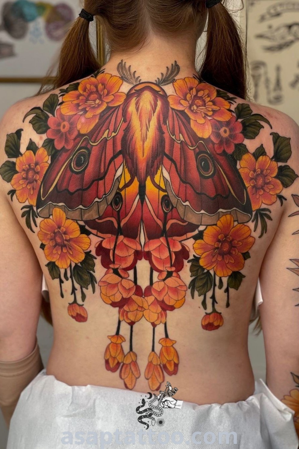 Elegant neo traditional back tattoo featuring a moth with flowers, a captivating design perfect for those seeking tattoos to melt your heart. Discover more amazing tattoo ideas at asaptattoo.com.