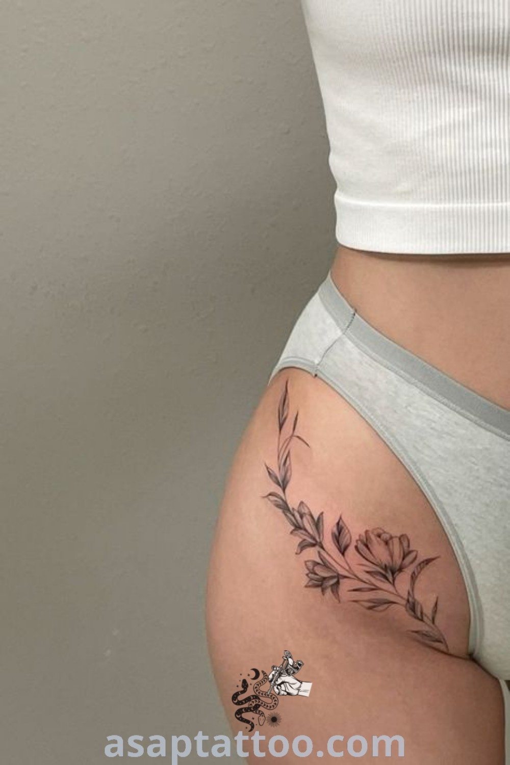 Elegant floral fine line tattoo on hip bone, featuring gorgeous flower designs. A must-see for women exploring pelvic tattoos and hip tattoo designs. Find inspiration at asaptattoo.com.