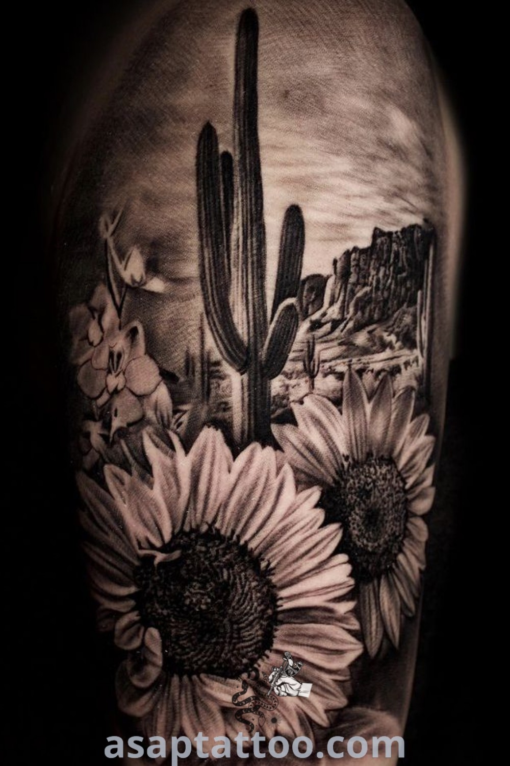 Black and white photo of a cactus with sunflowers, featuring Western inspired sleeve tattoos. This elegant design showcases the warmth of cowboy cowgirl tattoos and half sleeve Western tattoos for women. For amazing tattoo ideas, visit asaptattoo.com.