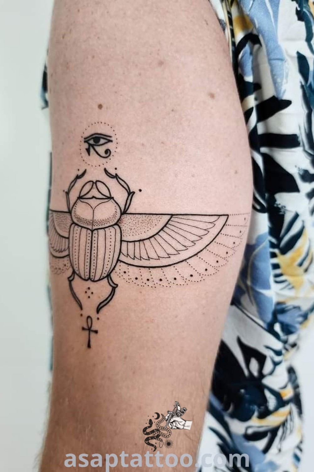 A man’s arm featuring an elegant scarab beetle tattoo, reflecting traditional Egyptian tattoo designs. This amazing tattoo art captures the essence of scarab symbolism, perfect for those looking for tattoos with meaning. Explore stunning ideas at asaptattoo.com.