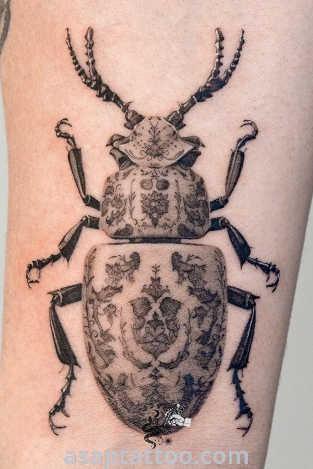 Intricate black and white beetle tattoo on the right leg with an amazing design. Perfect for bug tattoo lovers and those seeking elegant body art ideas. Find more inspiration at asaptattoo.com.