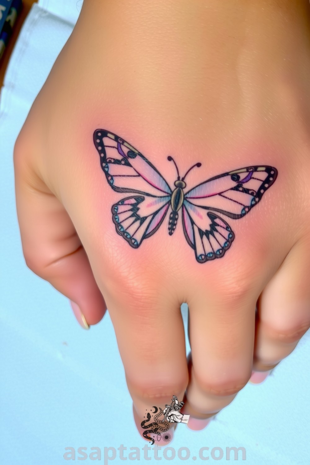 Delicate butterfly tattoo on the hand with intricate linework and a gradient from deep blue to soft purple, embodying grace and transformation. A gorgeous tattoo idea you must see. asaptattoo.com