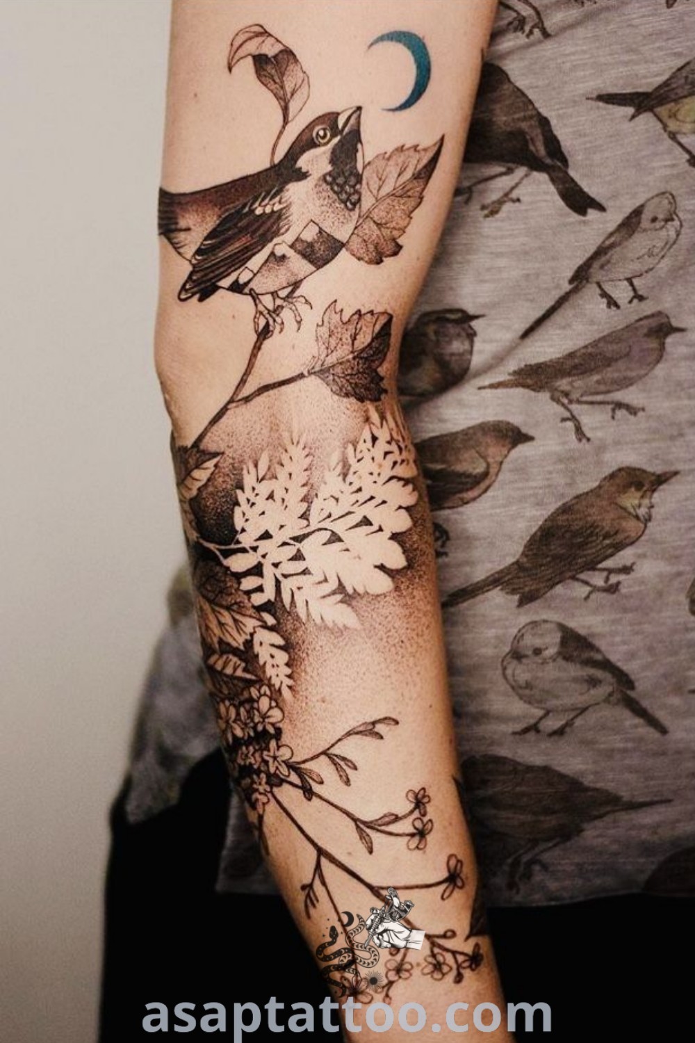 A person showcasing a stunning bird tattoo along with a vibrant bird design on their arm, combining black and white artistry with color elements. The captivating design serves as inspiration for tattoos with meaning. Discover more amazing tattoo ideas at asaptattoo.com.