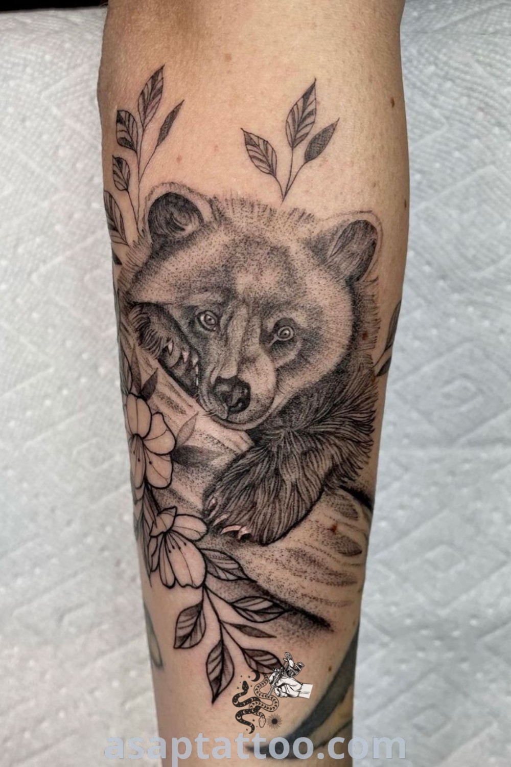 Black and white bear tattoo with flowers on its leg, showcasing artistic elements of bear sunflowers and floral designs. An inspiring idea for unique arm tattoos. Discover more at asaptattoo.com.