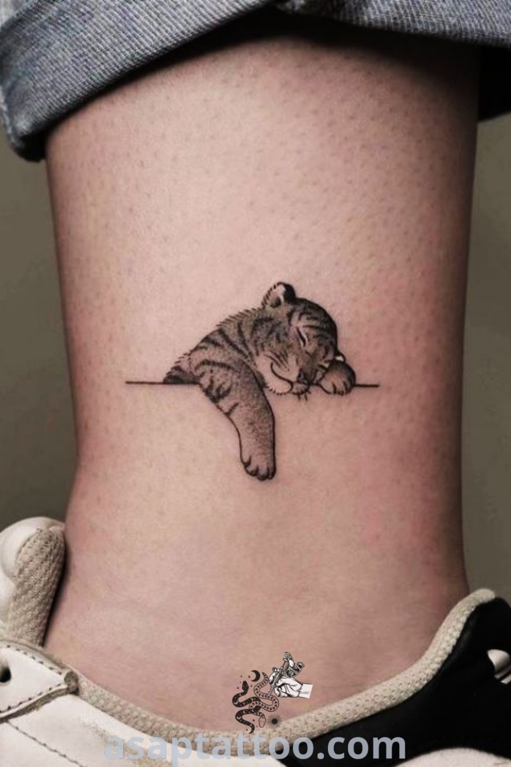 Small cat tattoo on the side of a woman