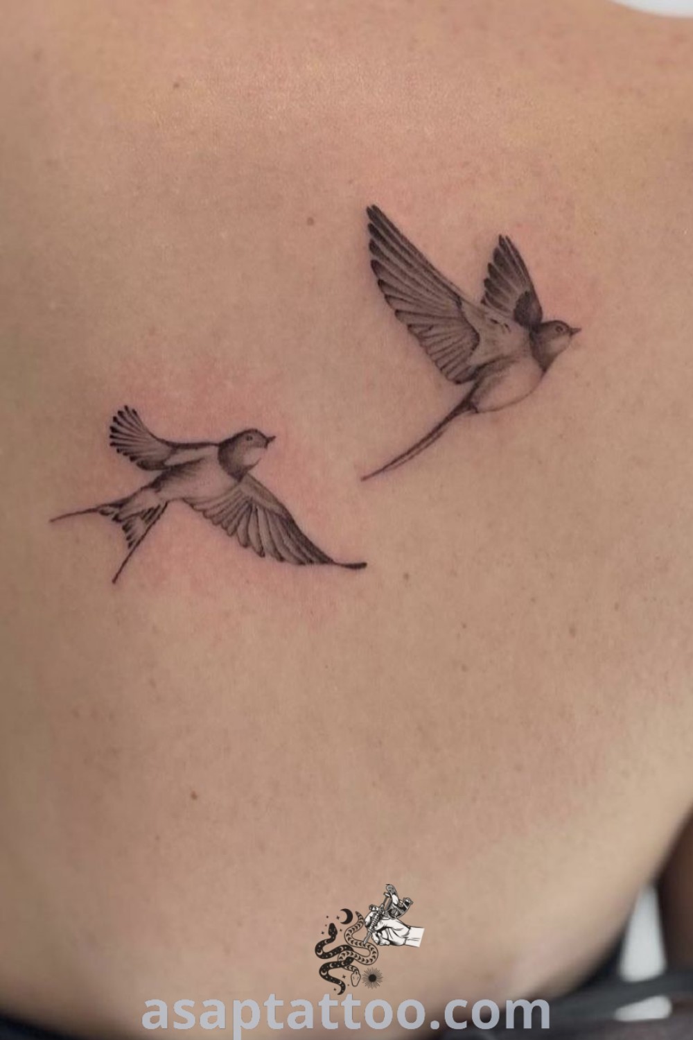 Elegant bird tattoo on the left shoulder featuring two small birds, one flying away, symbolizing friendship and freedom. This design is perfect for women looking for meaningful, gorgeous tattoos. Discover more amazing tattoo ideas at asaptattoo.com.