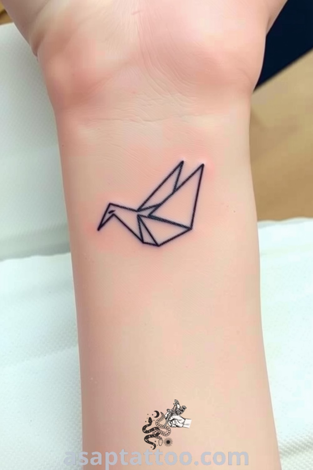Origami bird tattoo with fine linework and soft shading, showcasing intricate folds against light skin tone. An elegant tattoo idea you must see for its beauty and meaning. asaptattoo.com