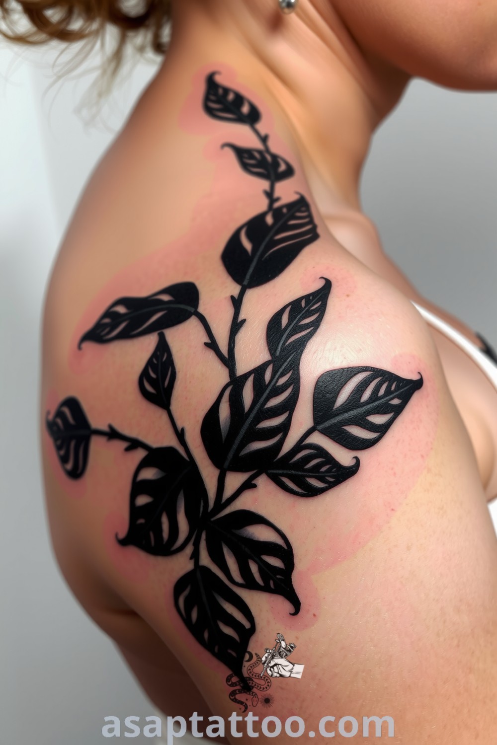 Chiaroscuro plants tattoo on the shoulder with high-contrast leaves and intricate linework, creating a stunning effect that enhances skin tones. An amazing tattoo design you must see to believe. asaptattoo.com