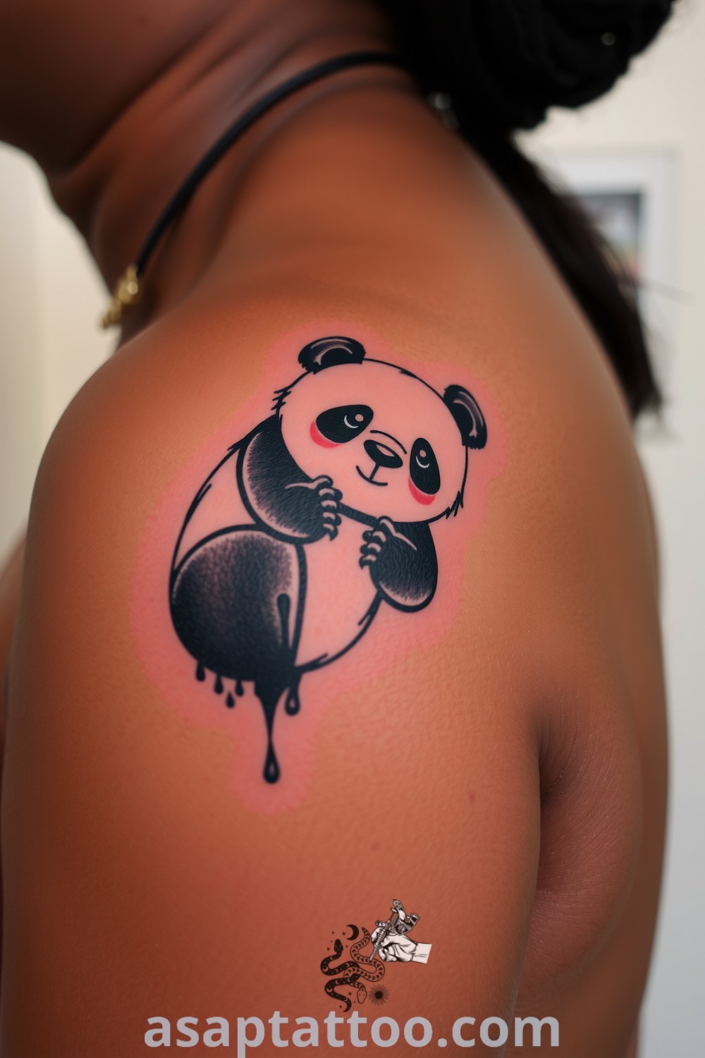 Playful panda tattoo on the shoulder featuring fluid lines and soft shading on dark skin, creating a whimsical and charming design. Amazing tattoo ideas you must see to believe. asaptattoo.com